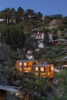While the floor plans are identical, the two story cantilevered houses are offset and have subtle differences in size and height that, along with frosting on some of the windows, enable the owners to retain privacy.