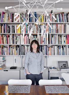 A second bedroom was converted into a home office/dining room. A Dieter Rams 606 Universal Shelving System lines the wall. Perhaps the most eye-catching item <br><br>in the room is the light fixture that hangs over their Swedish dining table. Patrick Townsend, the Queens-based designer of the Orbit chandelier, likens his wiry creation to a suspension bridge, but it looks suspiciously like a giant eggbeater.