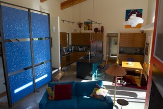 An accent wall, composed of cobalt-blue fractal panels from 3form, adds a bold dash of color to the great room. Barry Doyle built the kitchen cabinets with bookmatched koa veneer panels, giving them a distincitve, patterned look. Photo by Barry B. Doyle.