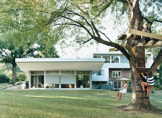 Mason and friends scramble around his soon-to-be tree house as Muriel swings. What remains of the original brick house can be seen on the right side of the structure, with the new master bedroom on top and living area on the left. A hot tub and seating area are accessible through the basement and living area.
