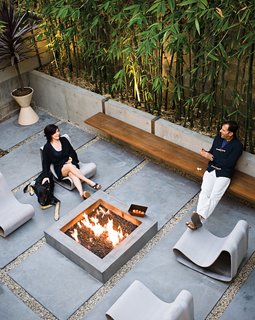 Jacobson and Lee designed the long steel-and-ipe bench, which suspends from the low concrete wall. Dukes relaxes on a Willy Guhl Loop chair with her German Shepherd, Major.