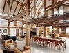 Modern home with Dining Room, Concrete Floor, Track Lighting, Chair, and Table. "We didn't want to diminish the openness and height and feeling of a great expanse of space," said the owner of this resurrected 19th-century barn house in Pine Plains, New York. Fortunately, the barn frame's horizontal beams perform a domestic function by creating the illusion of a lower ceiling. An abundance of furnishings in rich materials fills out the space. Photo by Raimund Koch. Photo of Examples of Rustic Modern Done Right