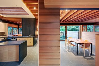 Two long, narrow structures intersect in an open kitchen marked by a contrasting maple veneer, creating distinct programmatic areas that look out toward a lush, tree-lined landscape. Two operable skylights positioned over the kitchen release warm air while drawing in the cool.