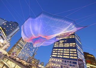 Sculpture Lets the Public Paint the Sky - Photo 1 of 4 - Janet Echelman’s "Skies Painted with Unnumbered Sparks"<br><br>Created to celebrate the 30th anniversary of the TED Conference and only up from March 15-22, the web of netting suspended between the Fairmont Waterfront and the Vancouver Convention Center was a wonder. Echelman says her work is, in part inspired by the idea of "feeling sheltered, but connected to the limitless sky," and the crowds that gathered and interacted seemed to feel similarly inspired.<br><br>Credit: Ema Peter