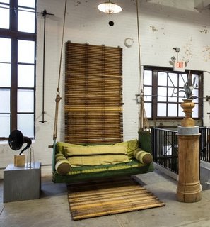 A unique custom porch swing hangs from the ceiling of the showroom.