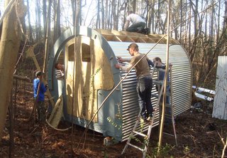 Exhibition Presents Design as a Force for Social Change - Photo 1 of 5 - Volunteers for Mad Housers Inc. build an enclosure out of wood and corrugated metal. The Atlanta-based nonprofit build modest structures for homeless people with a goal of giving them a sense of security, privacy, and dignity. Photo courtesy of Mad Housers Inc.