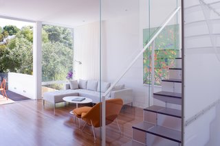 The living room, opposite the kitchen, provides a lounge area outfitted with a Womb chair and ottoman and Tulip coffee table by Eero Saarinen for Knoll and a Delano sectional sofa by Sphere Designs.<br><br>Photo by <br><br>Sharon Risedorph