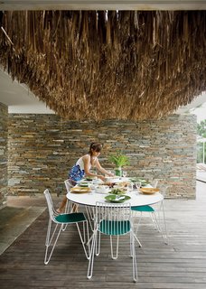 The Mourtzouchoses entertain constantly, which means that food is rarely far from anyone’s mind. Alexia sets a Tio table (with matching chairs) by Massproductions, over which hangs a thatch of dried palm fronds.