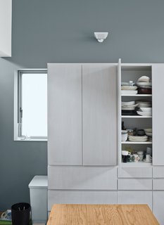 Small Box Home with Black Metal Facade in Japan - Photo 10 of 14 - White prefabricated cabinets and countertops make for a streamlined kitchen.
