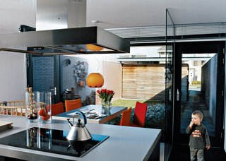 The kitchen is the entrance point for the Collettes’ home and its functional core. The warm colors of the house’s wood-and-brick exterior are continued in the felt covers of the Face chairs in umber, red, and rust—a vintage 1983 design for Montis by Gerard van der Berg. The cupboards are gray ("but a warm stone gray, not a cold corporate gray,"Dedy emphasizes). Dark stone was planned for the countertop but looked far too heavy. The couple chose Duropal, a stainless steel lookalike that’s easier to maintain.