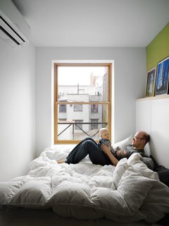 Storage-Smart Renovation in New York City - Photo 7 of 14 - The bed takes up nearly the entire master bedroom, but it doesn’t make the space feel cramped. The wide window keeps the tiny box light.