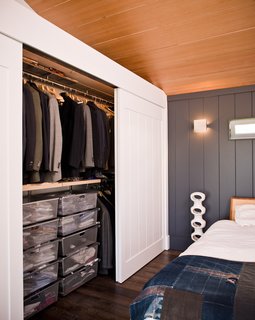 In the bedroom portion of the upstairs studio, a vintage Japanese indigo quilt from the Rose Bowl Swap Meet lies folded on the end of the George Nelson-designed bed, which is flanked by an Architectural Pottery floor lantern.