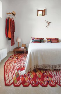 A Losanges rug by Ronan and Erwan Bouroullec, part of Marquina’s 2011 collection, anchors the master bedroom. The Básica Mínima bedside lamp is from Santa & Cole, and the kilim pillows, available online and in Marquina’s Barcelona shop, are by Philippe Xerri.