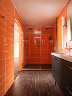 In this bathroom, Roca wall tile in Rainbow Azul continues the citrus color scheme, and the floor is clad in ceramic plank. 