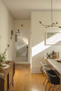The dining room adjacent to this clever Ikea kitchen hack includes some not so bargain-bin pieces, including Eames shell chairs from Herman Miller and a vintage Italian bar cart.