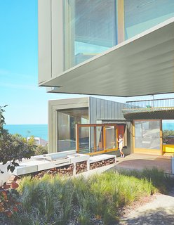 A sliding window between the kitchen and the barbecue area makes outdoor cooking a cinch. "In summer, we eat out there a fair amount," the wife says. Wardle chose zinc for the exterior to complement the trees that surround the house on its northern fringes.
