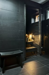 The ground-floor sauna, one of the home’s central gathering spots, is built from stained alder. The electric heater is from the Finnish company Iki.