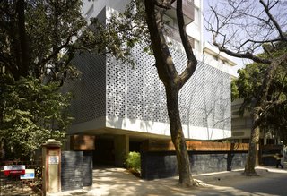 A Modern Aesthetic in Mumbai - Photo 3 of 17 - The entrance leads to an open walkway, sitting area and mail area beneath the open-air public floor of the building.
