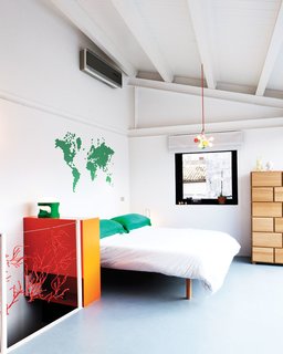 Stylish Sicilian Bedroom - Photo 1 of 1 - Francesco and Mafalda’s bedroom is open and playful with only a bit of Algue by Ronan and Erwan Bouroullec guarding the stairs. The lamp was designed by Francesco himself and the decal on the wall is from My Vinilo.