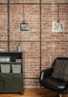 Abbes and Davison removed drywall to expose the brick on one wall in the living room. "As we began to expose that brick, we found the old metal framing that they used to use," Daivson says. "They used to stick chicken-mesh wire on it and put plaster on top. When we exposed the brick, we found this metal detail and decided to keep it." Photo by Alan Gastelum.