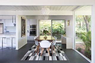 In an effort to create a more open floor plan, a portion of the wall between the kitchen, family area, and dining room was removed. Part of the dining room wall was also replaced with a huge window that not only makes a statement, but also gives the family a stunning view of the backyard area. Photo by Mariko Reed.