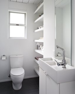 An all-white design brightens up the bathroom, making it feel serene and comfortable for the family. Photo by Mariko Reed.