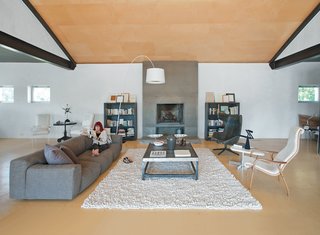 The seating area includes an extra-long sofa by Piero Lissoni, and a leather armchair designed by Alfredo Häberli for Moroso. The Twiggy lamp is from West Elm.