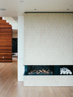 Tiles from Heath Ceramics surround the Ortal Clear 130LS fireplace. The white ceramic logs are by Klein Reid; the floor is oak.