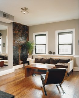 Hoagies' Heroes - Photo 7 of 13 - Peeling back plaster and drywall they unearthed beautiful brick walls. They opted to leave them exposed, letting light from the street and a wall of rough-hewn red brick warm up the large living rooms and kitchens. Mazza's living room sofa is from Crate and Barrel.