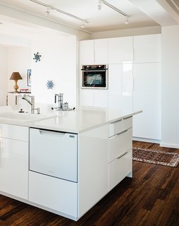 This Northern California Prefab Gets a Dose of Universal Design - Photo 5 of 8 - The kitchen, which sits at the center of the house, features recycled glass countertops, Ikea cabinets, and carbonized bamboo floors. "We had Thanksgiving dinner there," says the daughter. "There’s no sense of the house as small. It feels like a house."