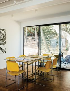 This Northern California Prefab Gets a Dose of Universal Design - Photo 7 of 8 - David Rowland stacking chairs join a 1970s Italian glass-and-steel table in the dining room. The daughter loves being able to stop in to visit. "I’m over there ten times a day. It’s brought me such peace."