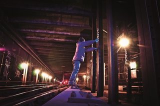 Graffiti artist standing on a wood covering over the third rail. Photo courtesy Jurne.