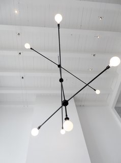 Lukas creates this lighting fixture by assembling metal conduit pieces from Lowe's. He also created a chandelier from hanging lanterns. "I like taking old materials and making something new." Photo courtesy of Lukas Machnik.