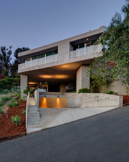 This cantilevered home by Escher GuneWardena Architecture in the Silver Lake neighborhood hovers above the sloping site, supported by five piers covered in vines. The architects sharply angled the street facade, offering views of the nearby lake. Photo by EGP Imaging.