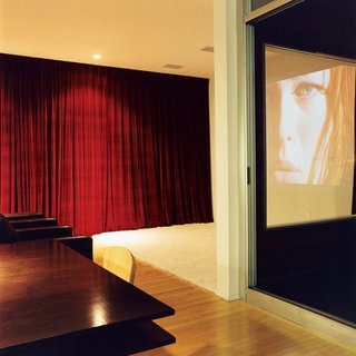 Making Sense of the City - Photo 7 of 11 - The kitchen transitions into the living room, which transforms easily into a home theater when the heavy red drapes are pulled tightly shut. The home theater system features a projector by Sharp.