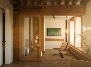 This Cozy Home Totally Changes How We Think of Tribeca Lofts - Photo 8 of 9 - A custom white oak sliding door fabricated by Markus Bartenschlager opens to a guest room with a Bilge lounge chair by Uhuru.