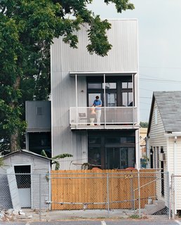 Resident Tony Vanky gets the second-story deck prepared for guests. The grittiness of the Black Pearl neighborhood is plainly visible.