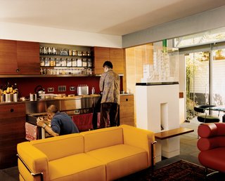The kitchen, clad in the same wood as the joinery walls, is designed like a self-contained piece of furniture.