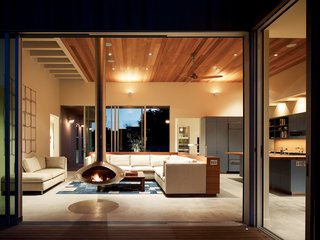 Although most radiant-heating systems are gas-powered, these ground-cement floors take the chill off with an electric warming system. Locally harvested cedar ceilings warm up the room and reach out to the matching siding, which was finished with a nontoxic bleaching oil to first speed, then arrest, the natural fading process.