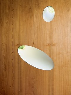 Irregular milled perforations form intriguing light wells in the skin of the house.