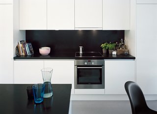 Sum of Its Parts - Photo 3 of 12 - Laminated-MDF cabinetry helps to hide clutter in the kitchen.