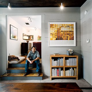 Dollahite perches on the steps to his living room beside his dog, who saw him through the entire renovation.