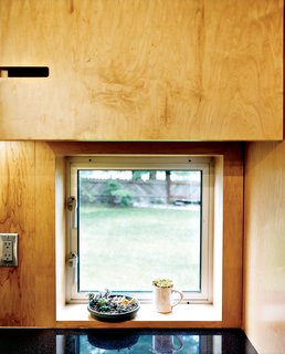 Magic Mountain - Photo 4 of 12 - Geometric notches in the kitchen cabinetry are simple and cost-effective substitutes for metal cabinet pulls—they also provide visual interest in an otherwise unadorned space.