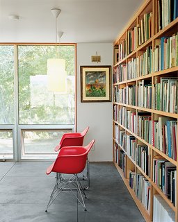 Up above the sitting room a duo of Eames shell chairs and a bank of luminous operable windows await a pair of weary readers.