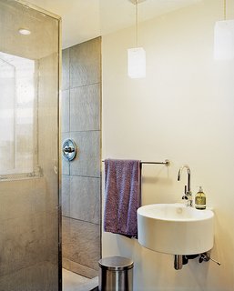 A perforated metal screen serves as a shower curtain.