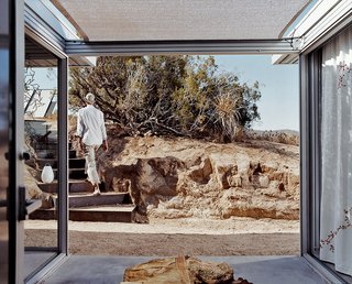 iT House, Joshua Tree - Photo 9 of 9 - A view out from the entrance lobby shows Koch leaving the house. He made the stairs' steel risers himself, with the help of his cousin, Chris Wilson.