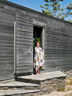 Emma Worple dries off from a swim at the cedar-clad sleeping cabin; the door slides shut to shield the cabin from harsh winter winds.
