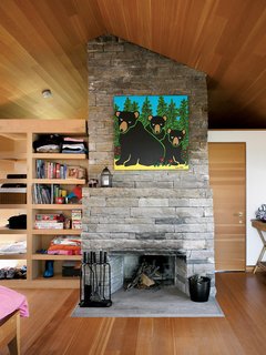 Inside the sleeping cabin, a fireplace built of local granite marks the midpoint between two bedrooms and a bathroom.