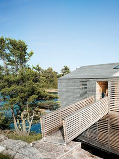 A footbridge connects the Floating House to the island.