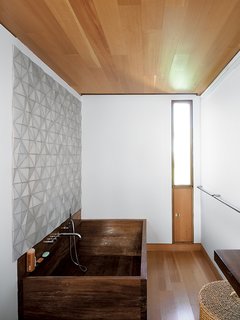 In the bathroom, a custom ceramic backsplash designed by Meredith and Sample joins an iroko-wood tub created by their students a the University of Toronto.